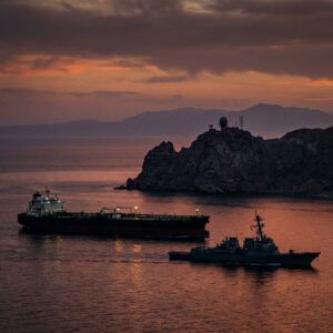 Oil tanker and naval ship at sunset