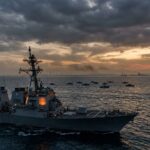 Naval warship at sea during dramatic sunset