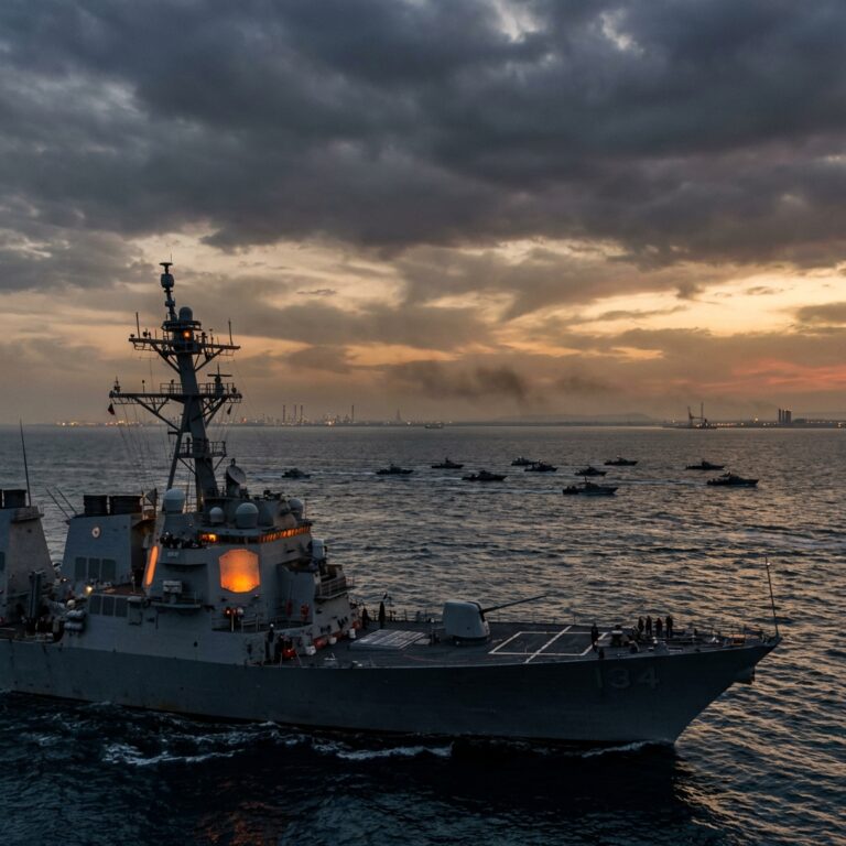 Naval warship at sea during dramatic sunset