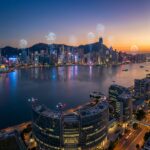 Futuristic city skyline with drones over harbour at sunset