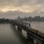 Freight train crossing bridge with North Korean flag